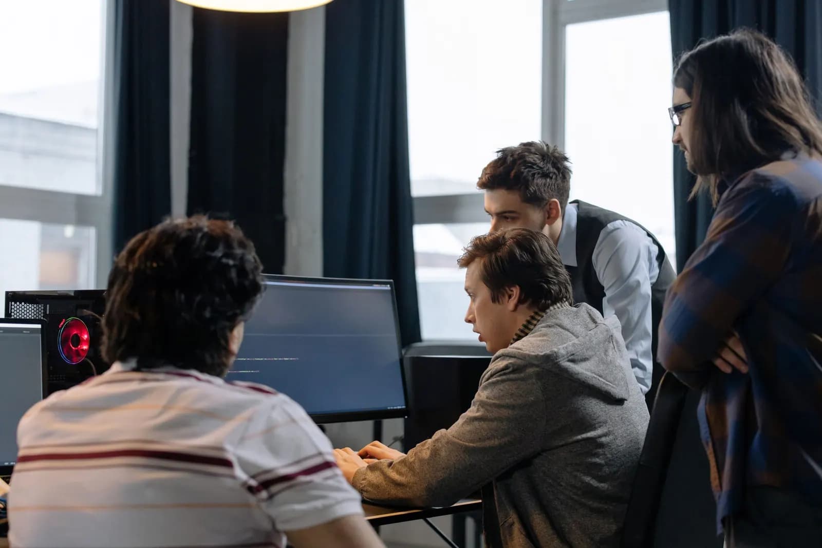 Colleagues discussing software development at a workstation